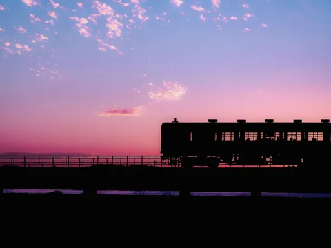 夕暮れ、静かに走り出す列車