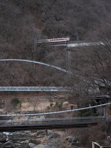 三層の橋と電車が走る渓谷
