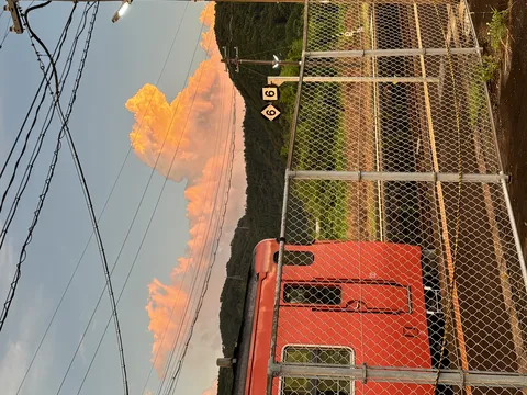 夕焼けに染まる空と赤い列車