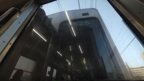 車窓に映る前方の電車「525」