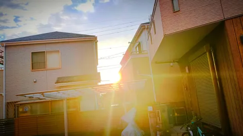夕日と軒下の光の粒