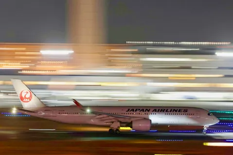 夜の滑走路を疾走するJAL機