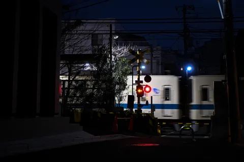 夜の踏切、疾走する光