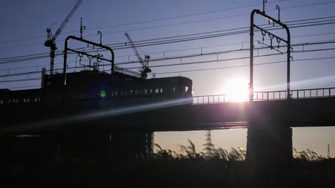 夕陽を浴びて走る電車のシルエット
