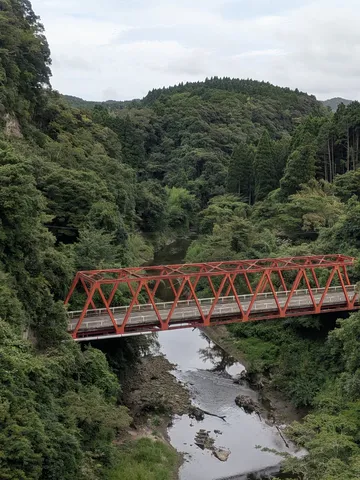 緑深き渓谷に架かる朱色の橋