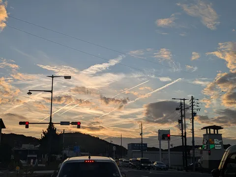 夕暮れ空に描かれた、飛行機雲の軌跡