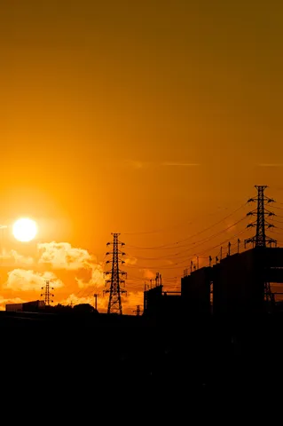 夕陽に染まる鉄塔と工場