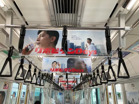 電車広告と吊り革の日常風景