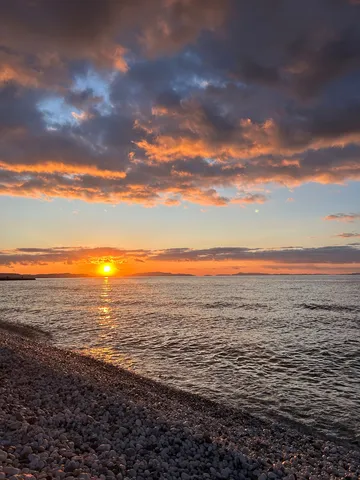 夕暮れの海岸線と燃える雲