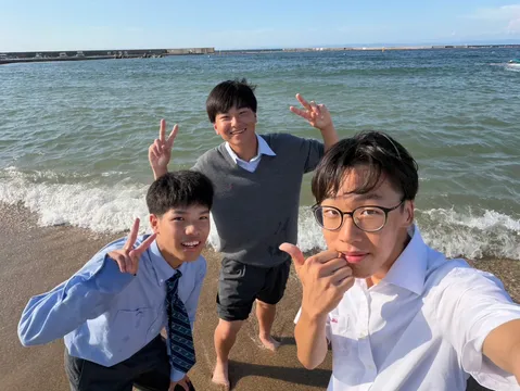 夏の海辺でピースサイン