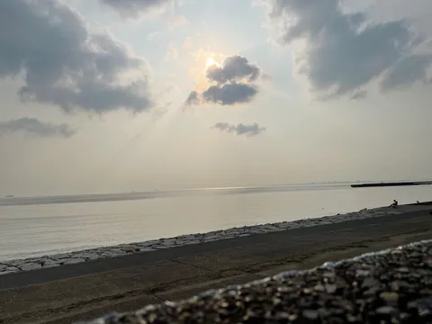 雲間から差し込む光、静かな海辺