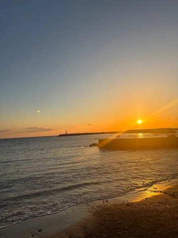 夕日と灯台、波打ち際のコントラスト