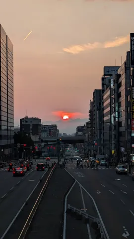 夕暮れの街、飛行機雲と太陽