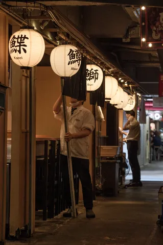 提灯の灯る路地で働く人々