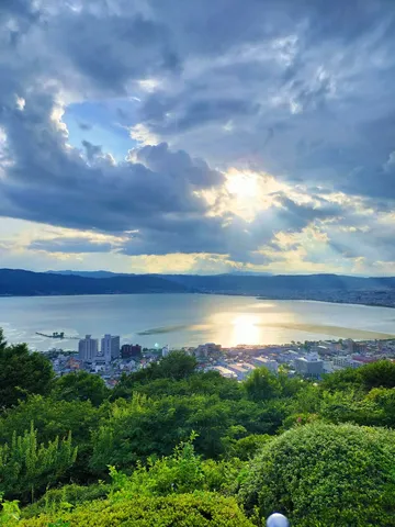 雲間からの光芒と湖畔の街