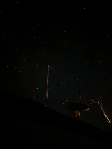 星空とアンテナ、都会の夜景