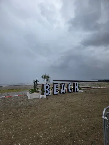 曇り空のビーチに立つBIGな「BEACH」