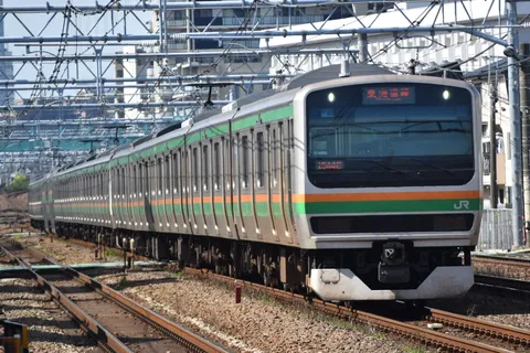 都会を駆ける、緑の帯の列車
