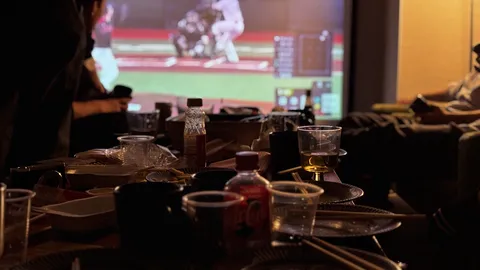 散らかった食卓とスクリーン観戦