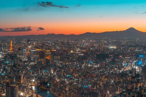 都市の光彩と染まる空、富士を望む