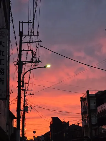 都会の空に溶ける、燃えるような夕焼け