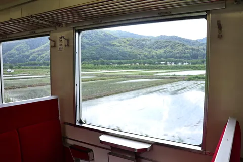 田んぼと山、列車の窓からの風景