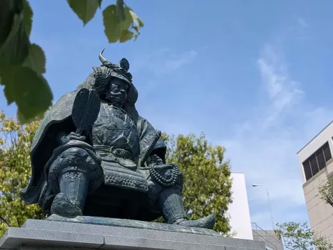 青空の下、威厳ある武将像