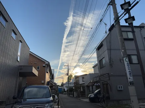 夕暮れに伸びる飛行機雲の道