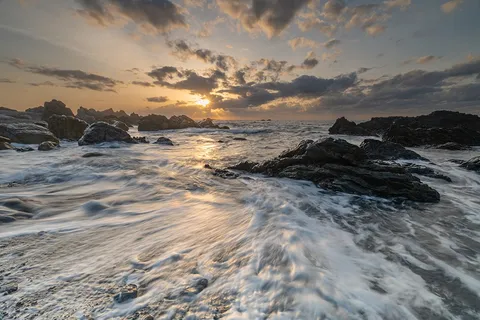 岩を洗う波と夕焼け