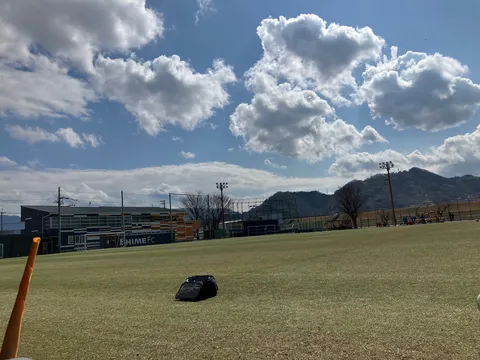 青空に浮かぶ雲とサッカー場