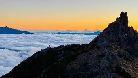 雲海を抜ける荒々しい山頂