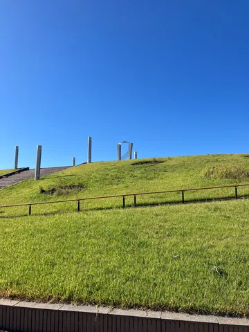青空と金属柱の草原景色