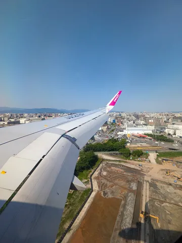 青空に映える翼と街のパノラマ