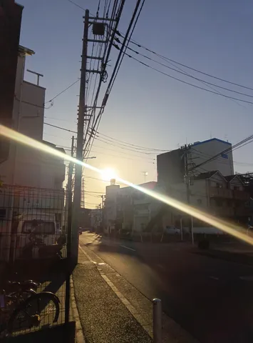 電線の向こう、夕日の道