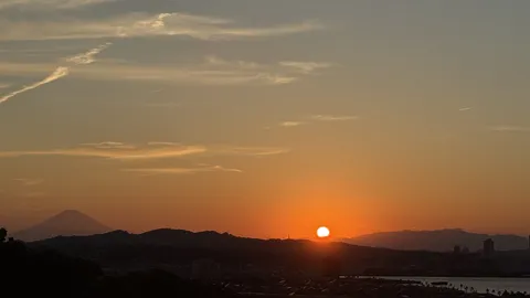沈む夕日とシルエット富士
