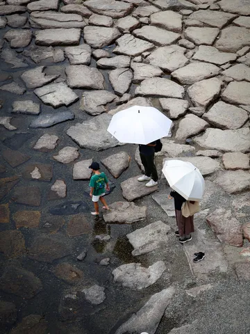 石畳と水面、傘越しの情景