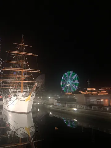 夜の港に浮かぶ光の帆船