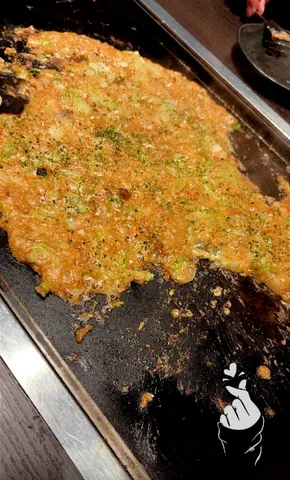 鉄板に広がるお好み焼きの旨味