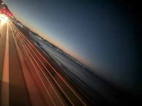 夕暮れの海と橋の影