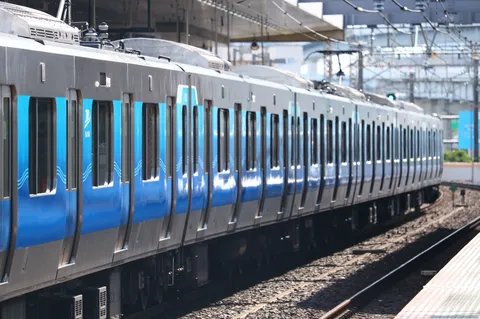 青いラインが印象的な、疾走する列車