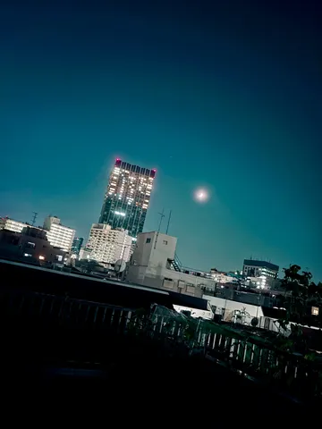 都会の夜空に浮かぶ光