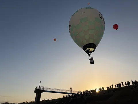 夕焼け空を舞う熱気球の祭典