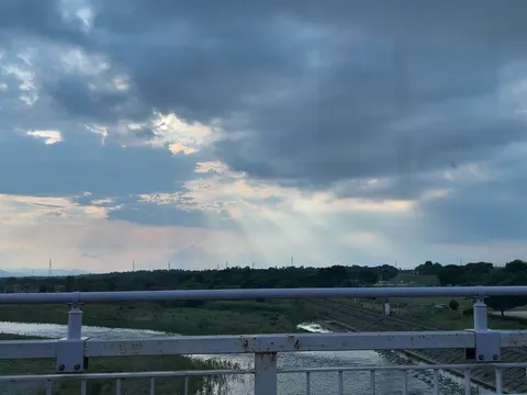 夕暮れ時の光芒、静かな河川敷