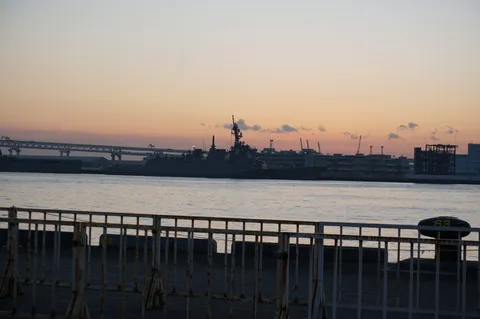 夕暮れ時の港、船と橋のシルエット