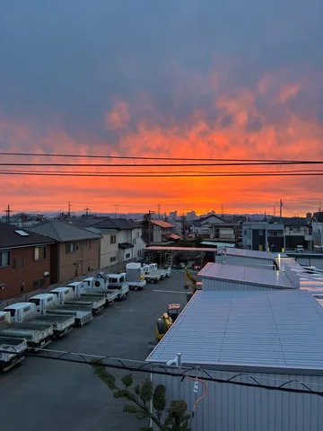 燃える空と働く車の静かな朝