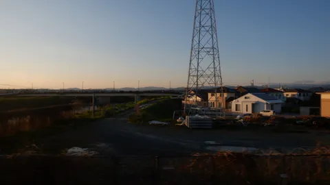 夕暮れの送電線と住宅街