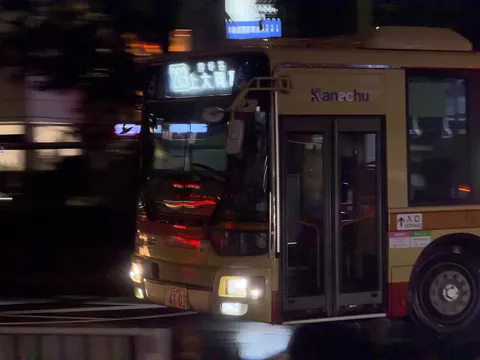 夜の路地を走る黄色いバス