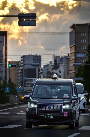 夕暮れの街を走るタクシー