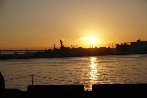 港に沈む夕日と軍艦