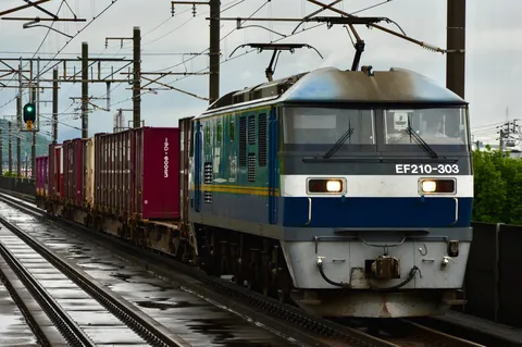 雨上がりのレールを駆ける貨物列車